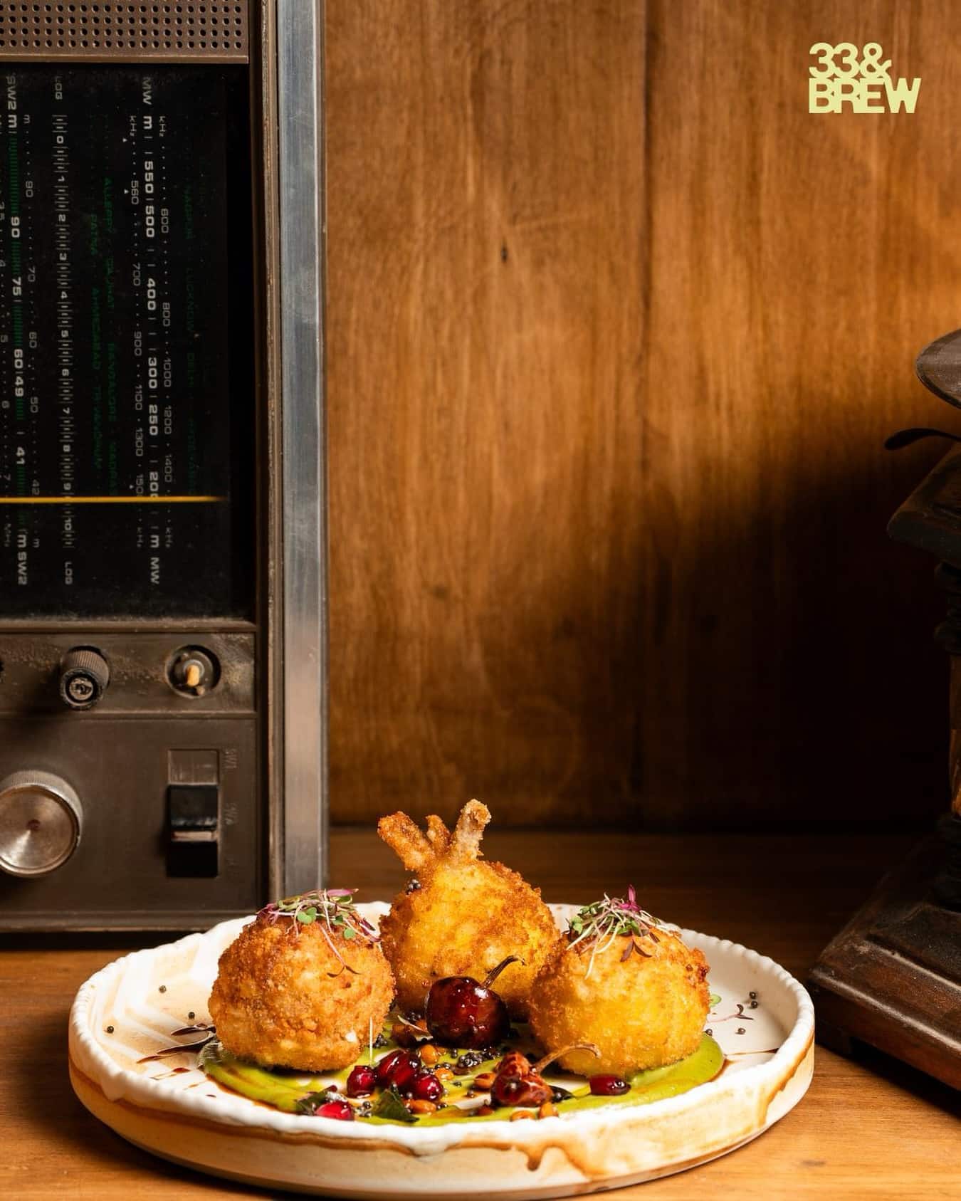 Crumbed croquettes plated beside a vintage radio at 33&BREW