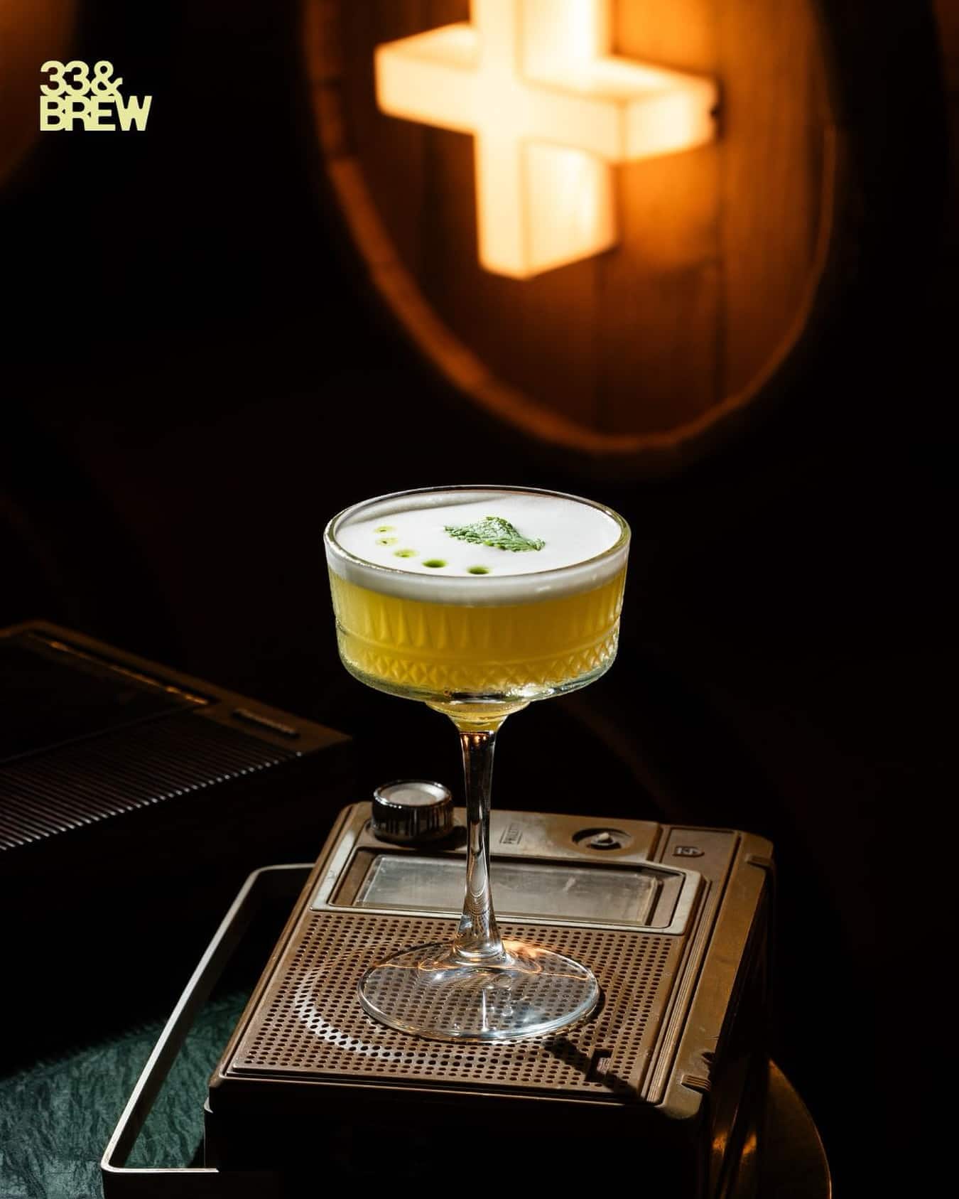 Signature cocktail served on a vintage tape deck at 33&BREW
